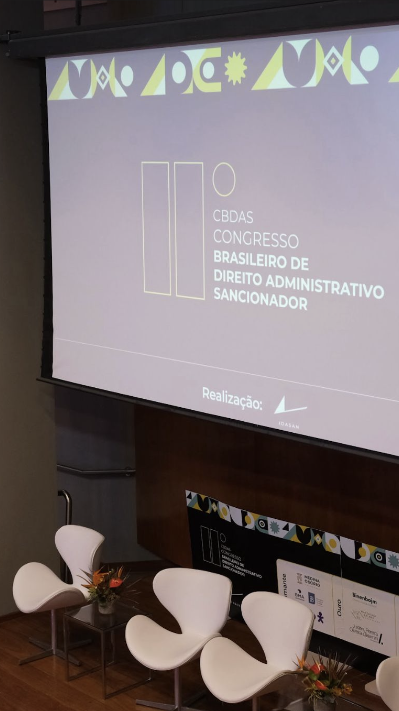 Registro vertical de participantes do congresso no auditório durante a programação.