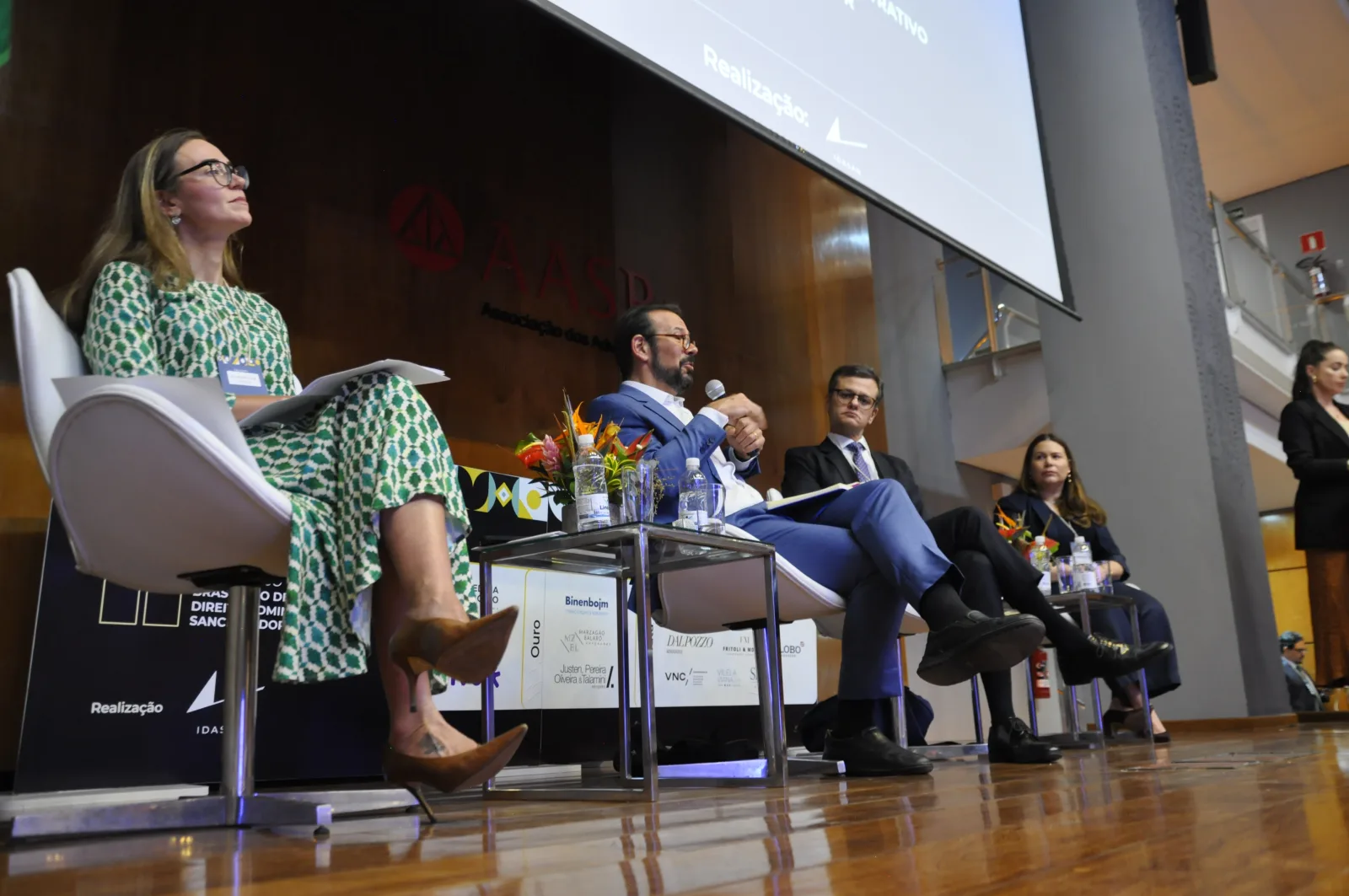 Participantes do congresso durante mesa e interação no auditório.